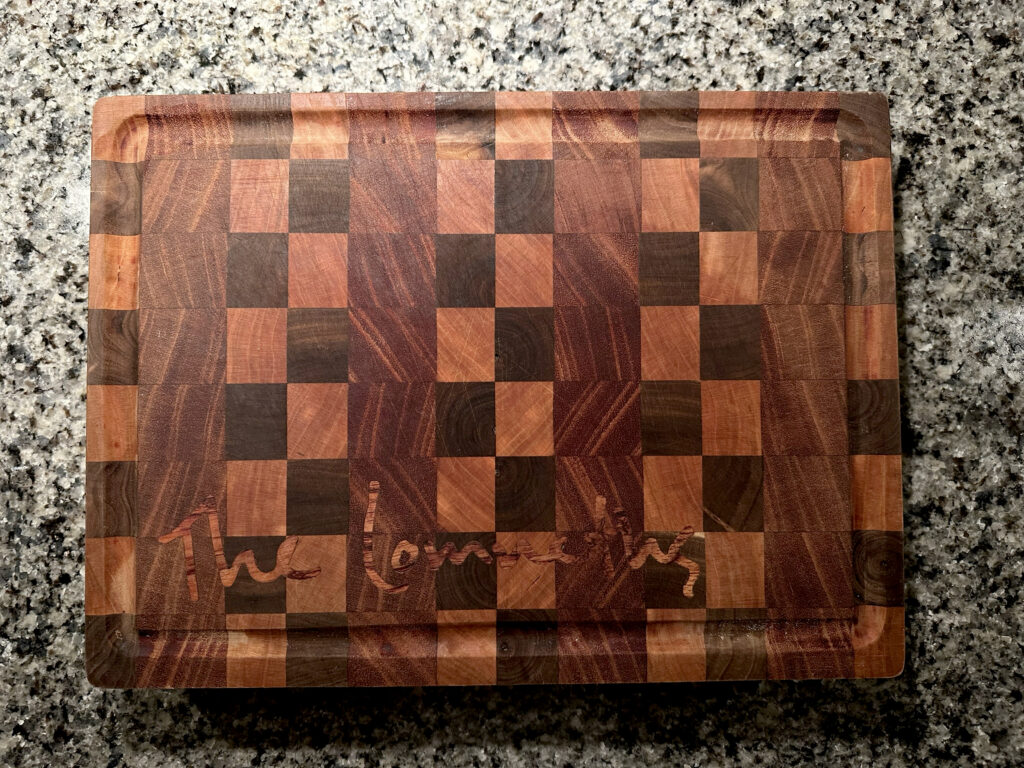 cutting board with inlaid wood signature reading "The Lomneths"